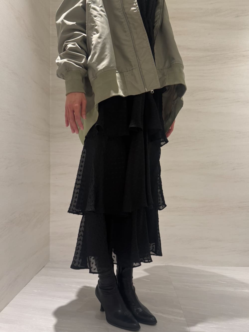 グリーン系のMA-1、ブラック系のワンピースを着用したレディースの冬コーディネートの4枚目の写真