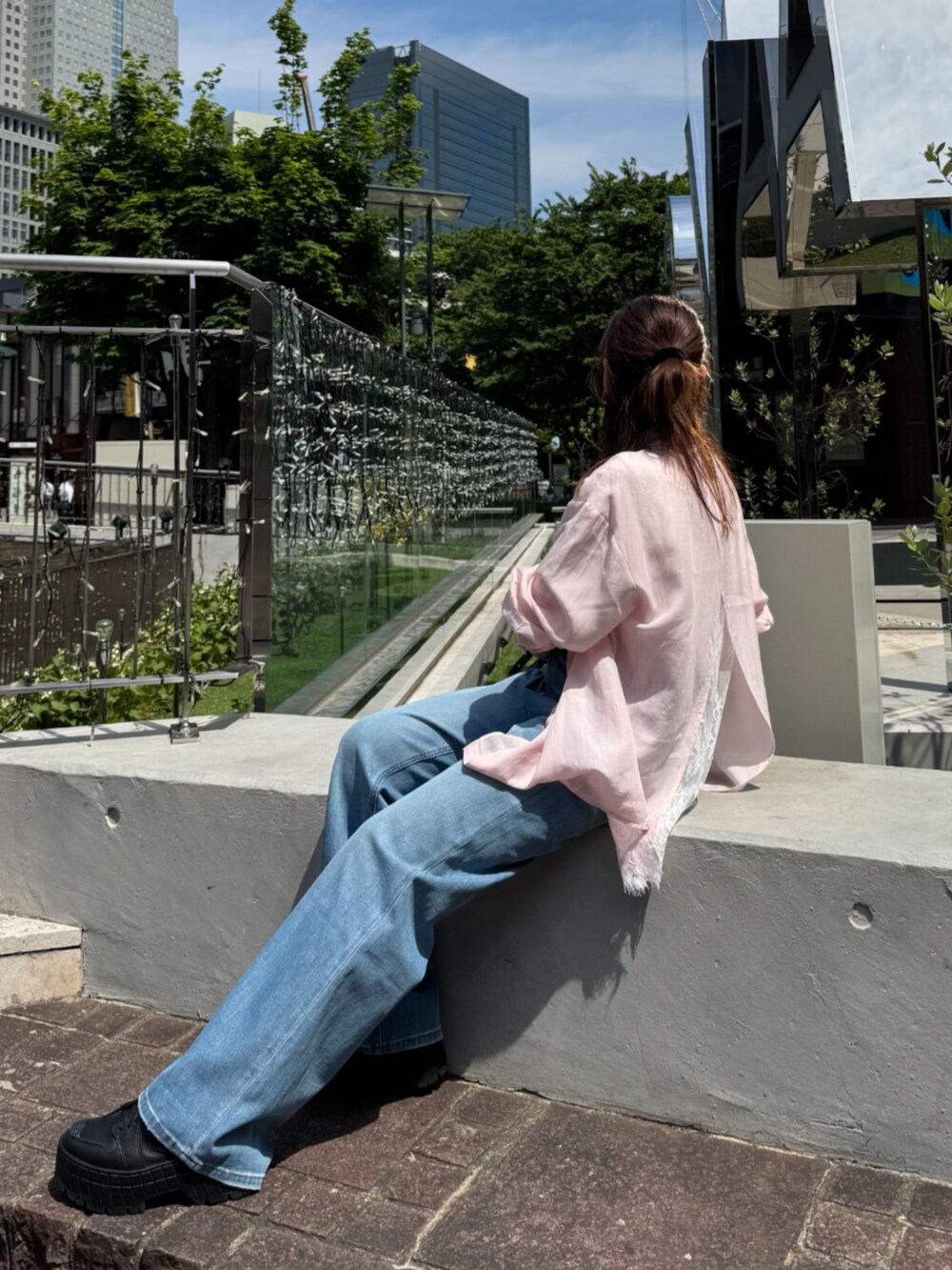 ブラック系のショルダーバッグ、ブルー系のデニムパンツ、ピンク系のシャツ/ブラウスを着用したレディースの夏コーディネートの7枚目の写真
