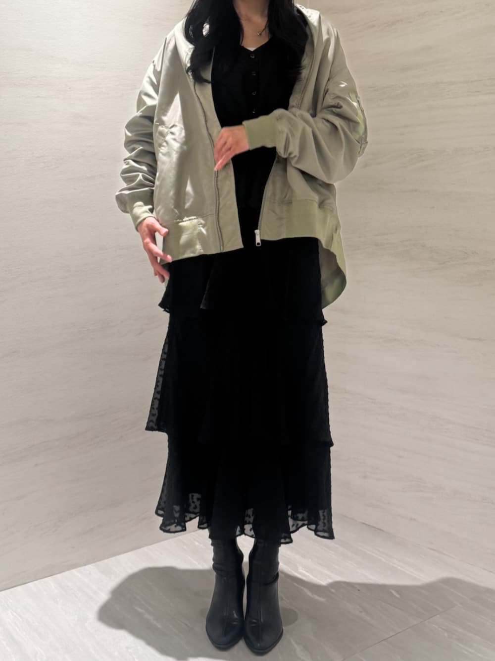 グリーン系のMA-1、ブラック系のワンピースを着用したレディースの冬コーディネートの3枚目の写真