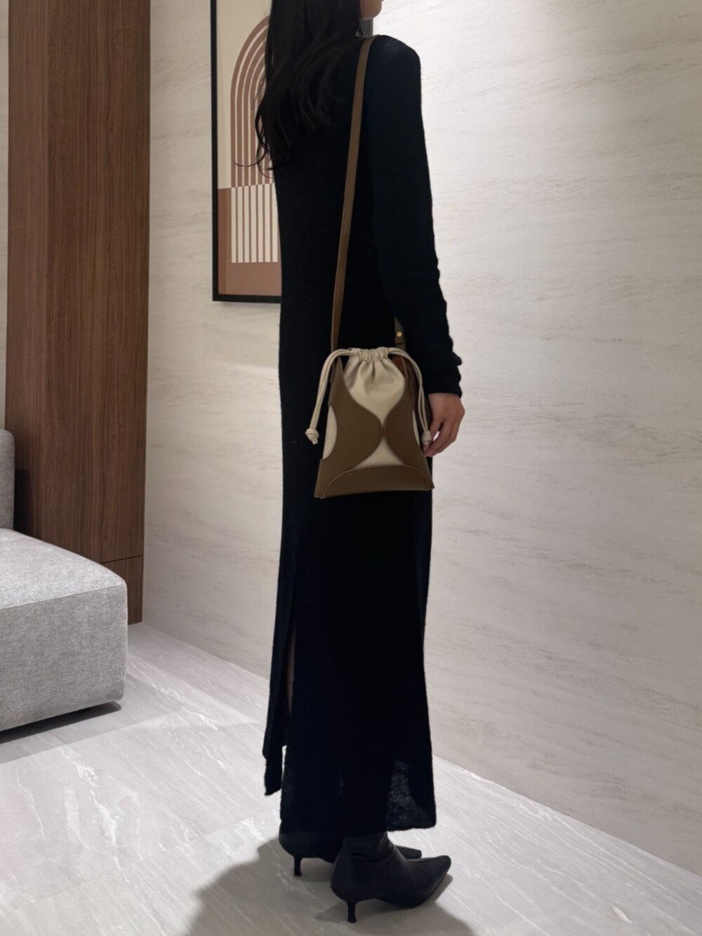 イエロー系のショルダーバッグ、ブラック系のワンピースを着用したレディースの冬コーディネートの3枚目の写真