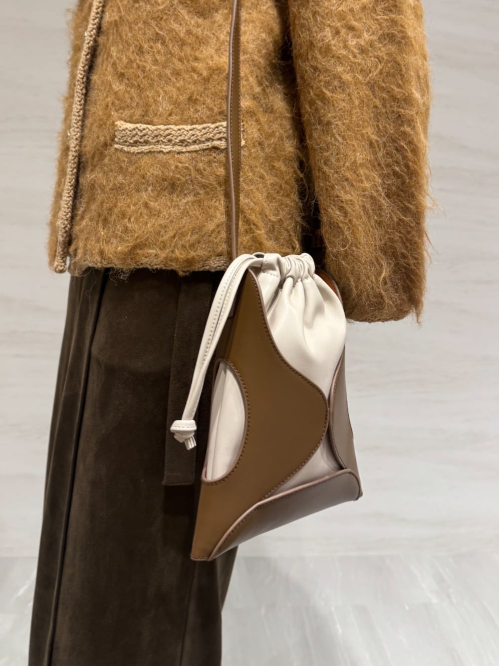 ブラウン系のスカート、イエロー系のショルダーバッグ、イエロー系のカーディガン/ボレロを着用したレディースの冬コーディネートの7枚目の写真