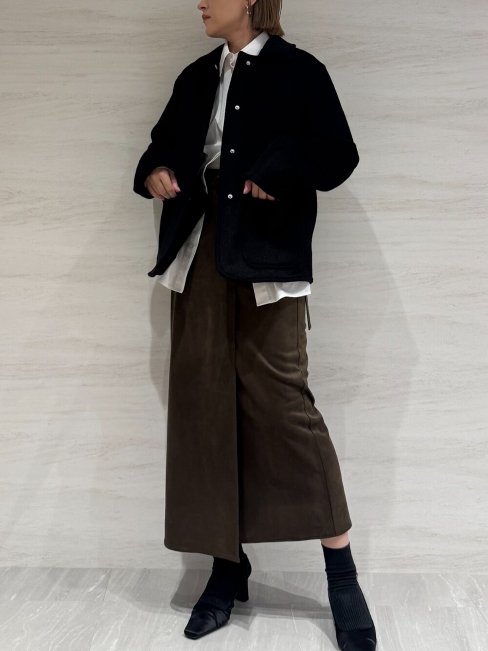 ホワイト系のシャツ/ブラウス、ブラウン系のスカート、ブラック系のブルゾンを着用したレディースの秋コーディネートの3枚目の写真