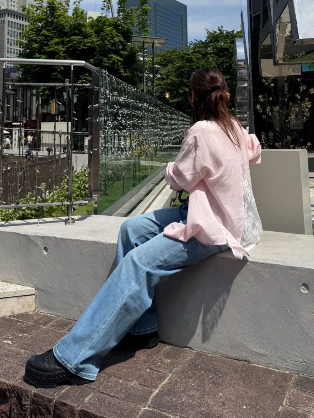ブラック系のショルダーバッグ、ブルー系のデニムパンツ、ピンク系のシャツ/ブラウスを着用したレディースの夏コーディネートの8枚目の写真