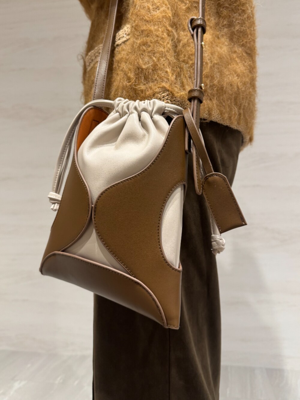 ブラウン系のスカート、イエロー系のショルダーバッグ、イエロー系のカーディガン/ボレロを着用したレディースの冬コーディネートの8枚目の写真