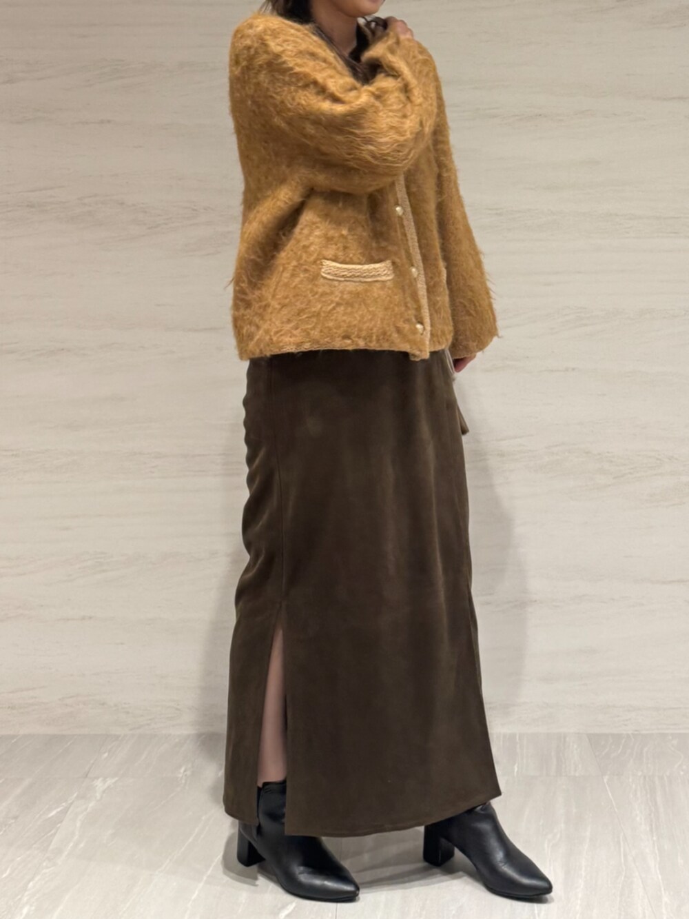 ブラウン系のスカート、イエロー系のショルダーバッグ、イエロー系のカーディガン/ボレロを着用したレディースの冬コーディネートの6枚目の写真