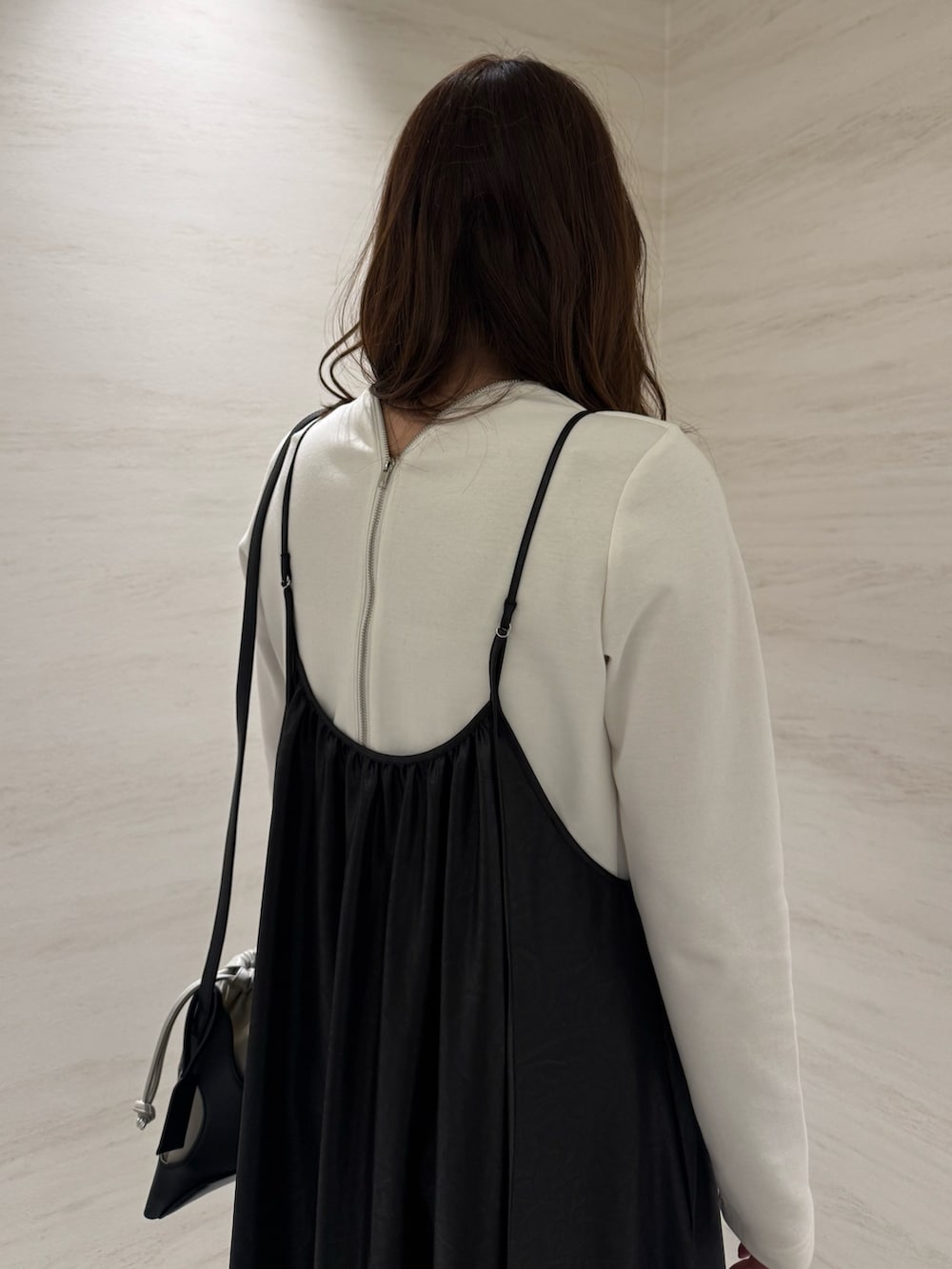 ブラック系のワンピース、ブラック系のショルダーバッグ、ホワイト系のTシャツ/カットソーを着用したレディースの春コーディネートの5枚目の写真