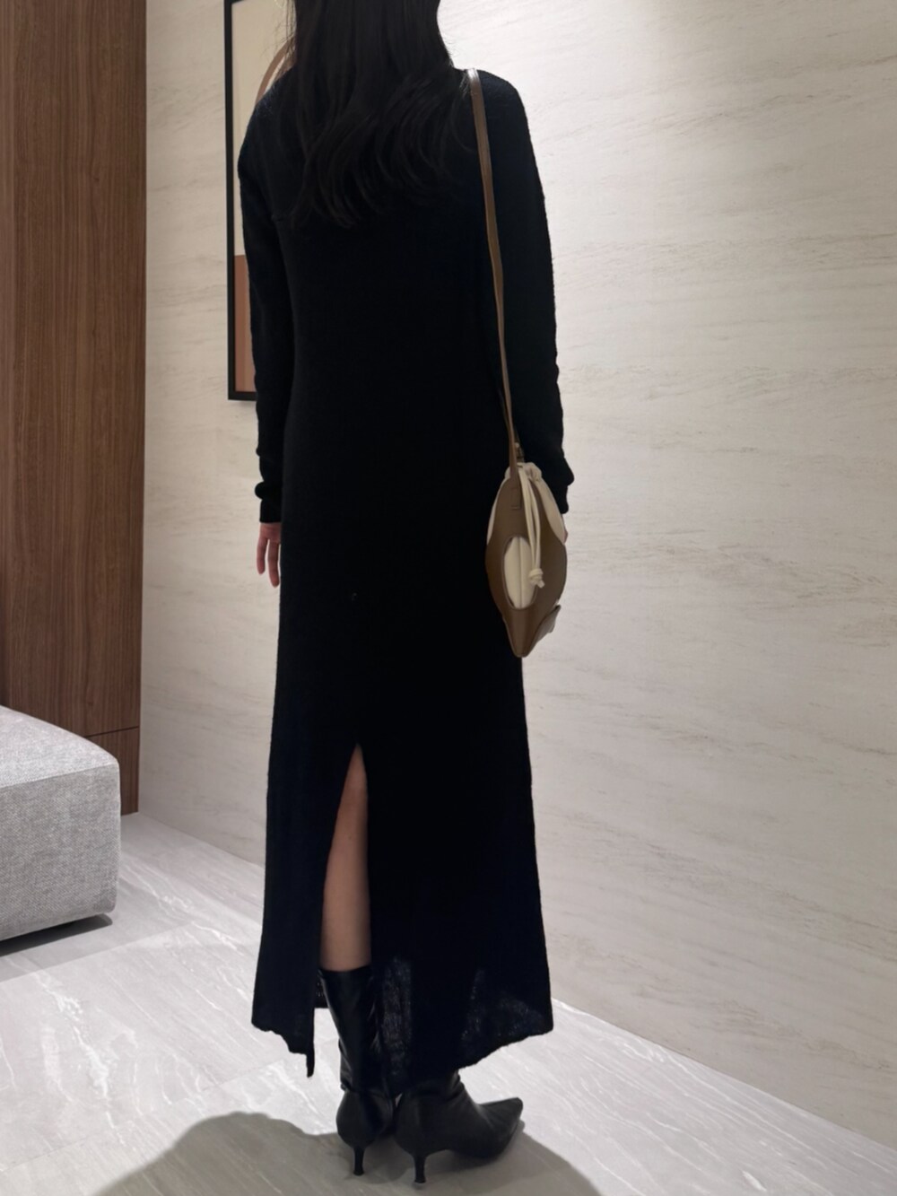 イエロー系のショルダーバッグ、ブラック系のワンピースを着用したレディースの冬コーディネートの4枚目の写真