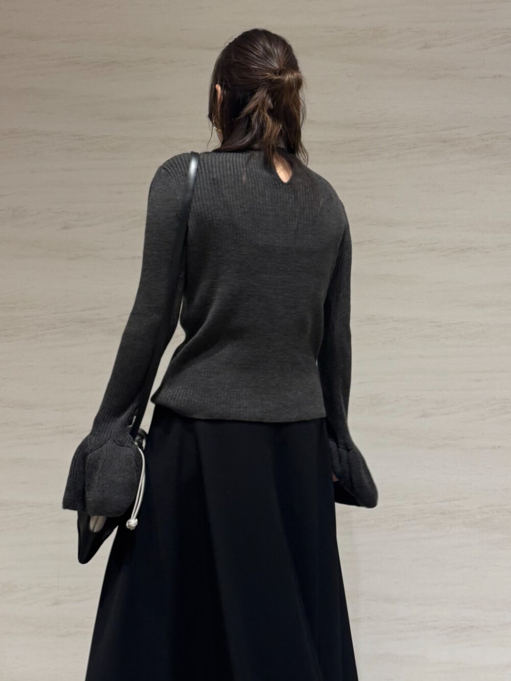 ブラック系のスカート、グレー系のニット/セーター、ブラック系のショルダーバッグを着用したレディースの秋コーディネートの6枚目の写真