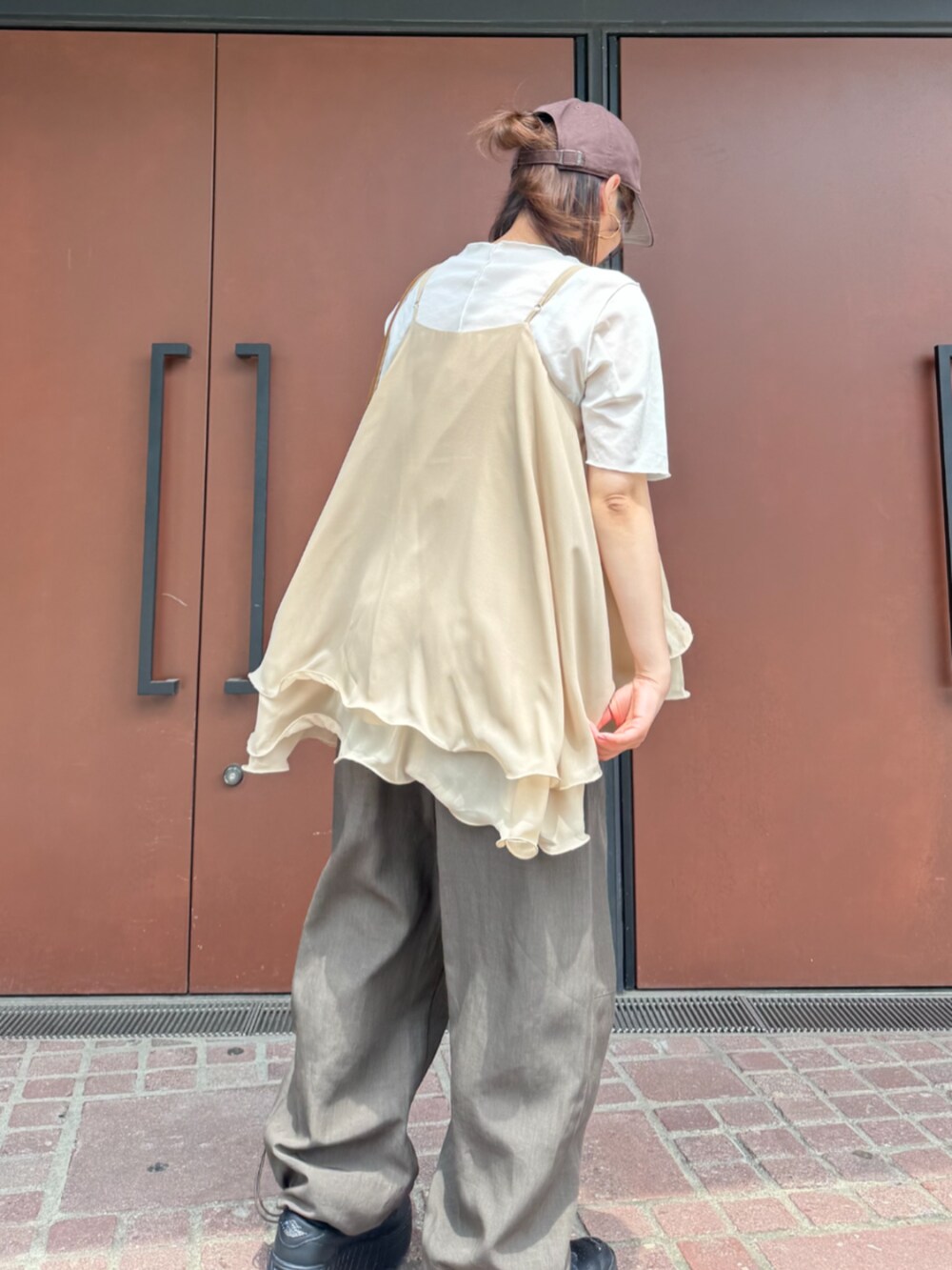 イエロー系のショルダーバッグ、ベージュ系のキャミソール、ブラウン系のその他パンツを着用したレディースの夏コーディネートの4枚目の写真