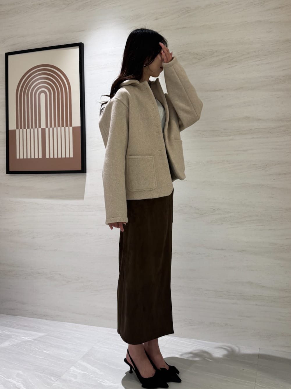 ホワイト系のTシャツ/カットソー、ブラウン系のスカート、ホワイト系のブルゾンを着用したレディースの冬コーディネートの4枚目の写真