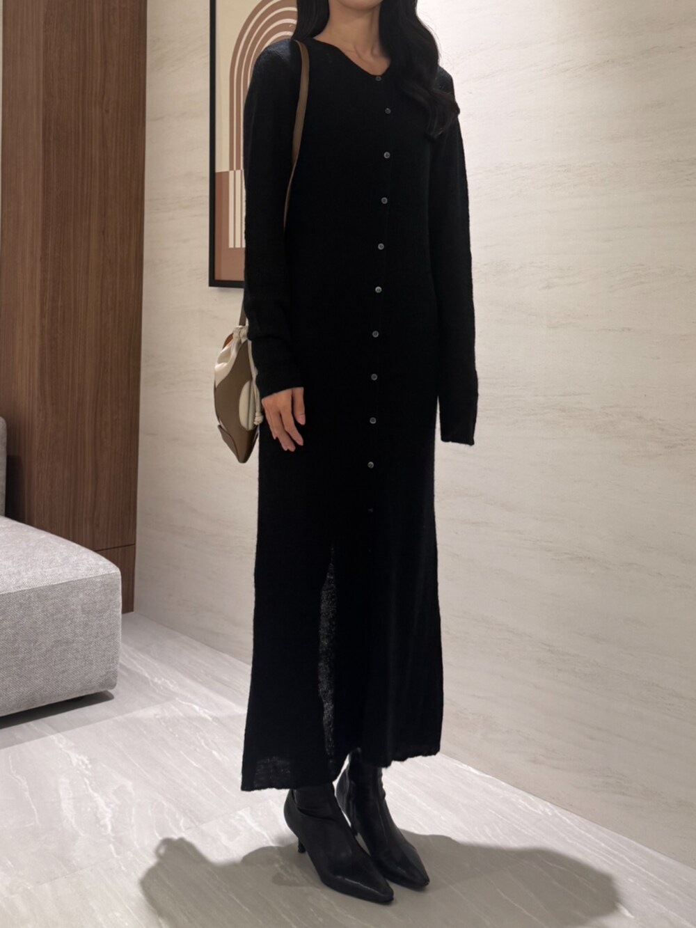 イエロー系のショルダーバッグ、ブラック系のワンピースを着用したレディースの冬コーディネートの2枚目の写真