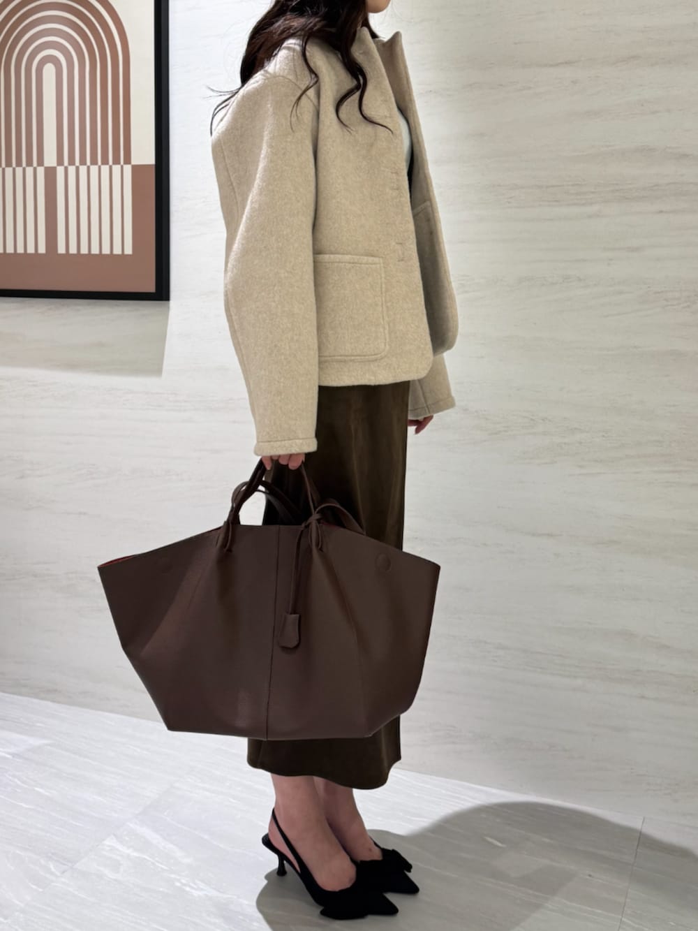 ホワイト系のTシャツ/カットソー、ブラウン系のスカート、ホワイト系のブルゾンを着用したレディースの冬コーディネートの5枚目の写真