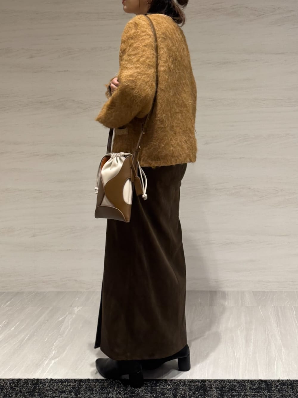 ブラウン系のスカート、イエロー系のショルダーバッグ、イエロー系のカーディガン/ボレロを着用したレディースの冬コーディネートの3枚目の写真