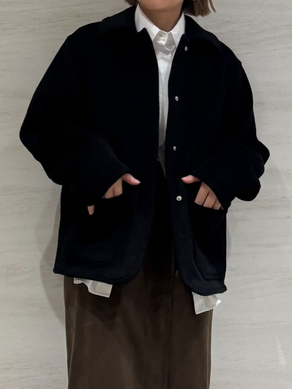 ホワイト系のシャツ/ブラウス、ブラウン系のスカート、ブラック系のブルゾンを着用したレディースの秋コーディネートの4枚目の写真