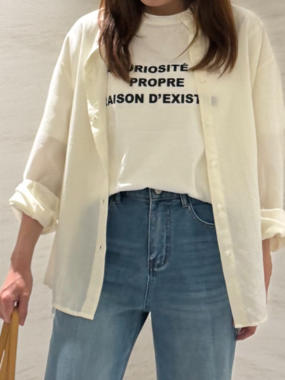 ベージュ系のトートバッグ、ブルー系のデニムパンツ、ホワイト系のシャツ/ブラウスを着用したレディースの夏コーディネートの5枚目の写真
