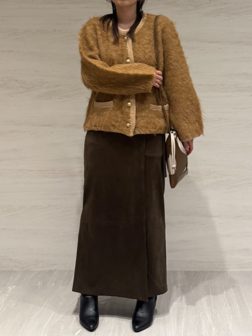 ブラウン系のスカート、イエロー系のショルダーバッグ、イエロー系のカーディガン/ボレロを着用したレディースの冬コーディネートの5枚目の写真