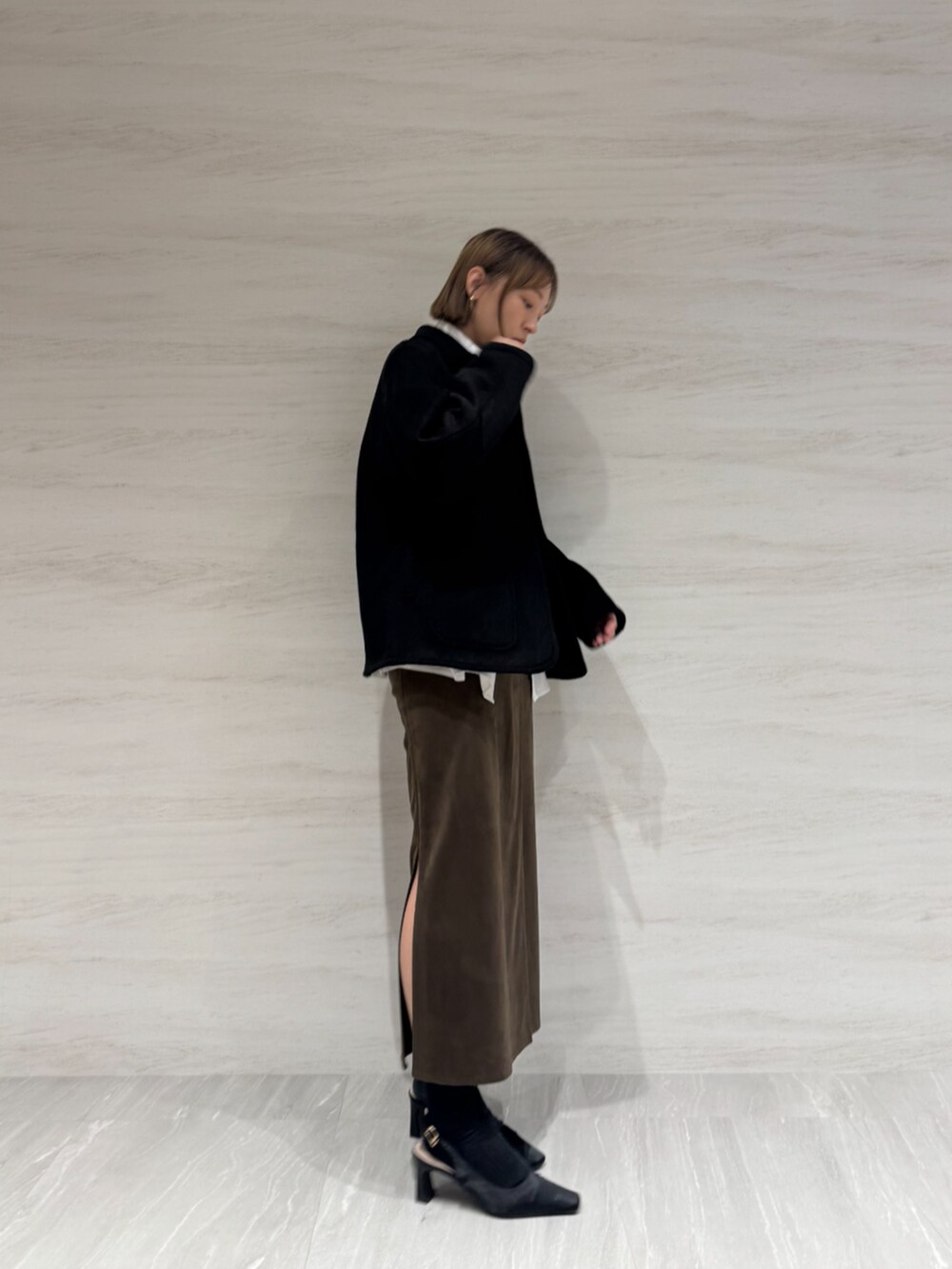 ホワイト系のシャツ/ブラウス、ブラウン系のスカート、ブラック系のブルゾンを着用したレディースの秋コーディネートの2枚目の写真