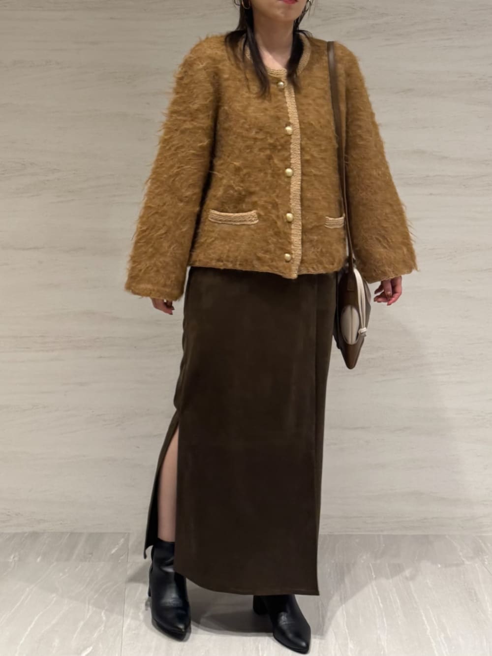 ブラウン系のスカート、イエロー系のショルダーバッグ、イエロー系のカーディガン/ボレロを着用したレディースの冬コーディネートの4枚目の写真