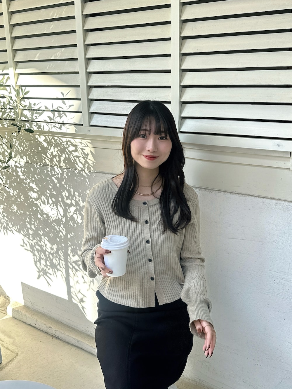 ベージュ系のニット/セーター、ブラック系のスカートを着用したレディースの冬コーディネートの2枚目の写真