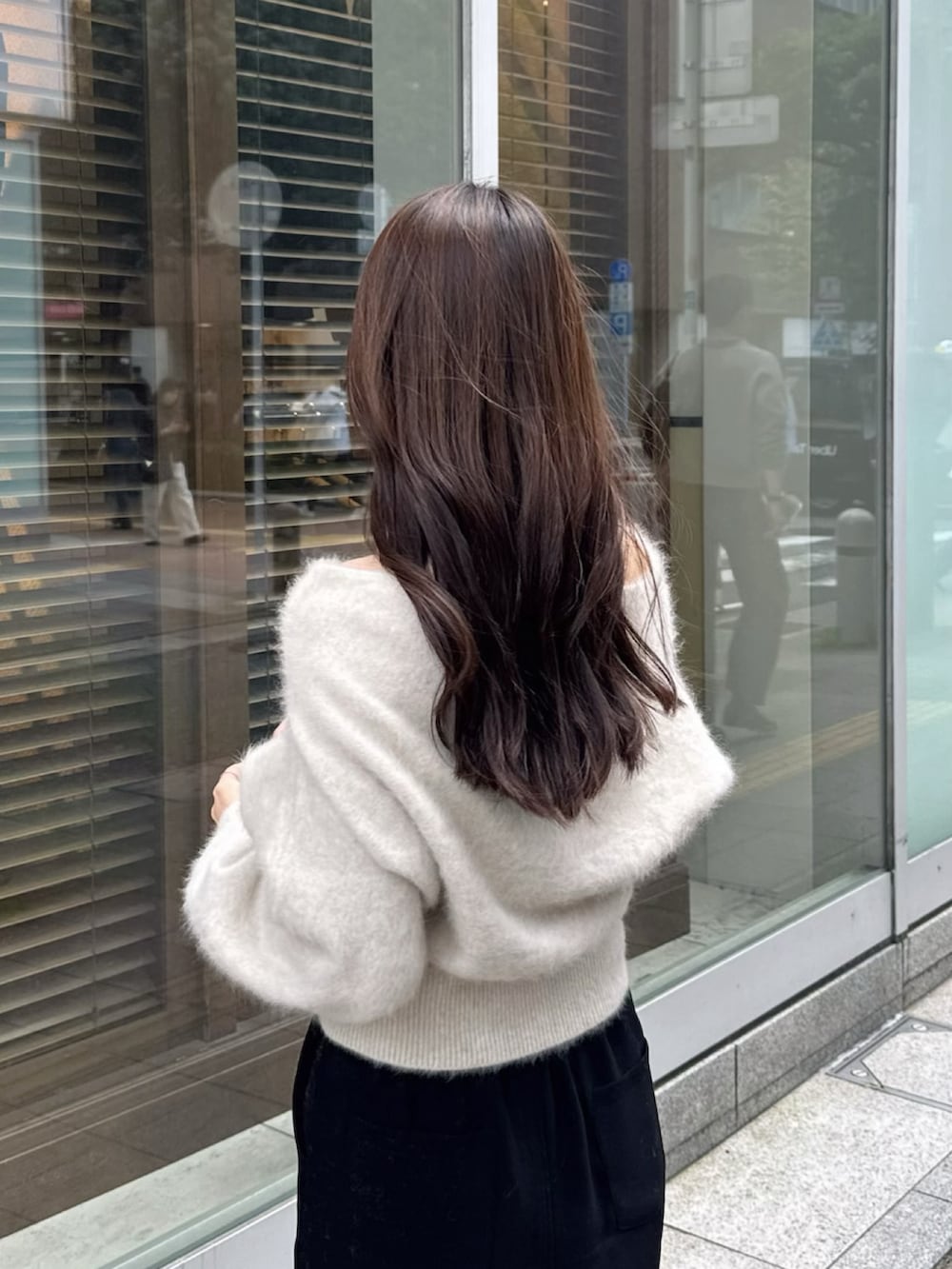 ホワイト系のニット/セーター、ブラック系のハンドバッグ、ブラック系のスカートを着用したレディースの冬コーディネートの2枚目の写真