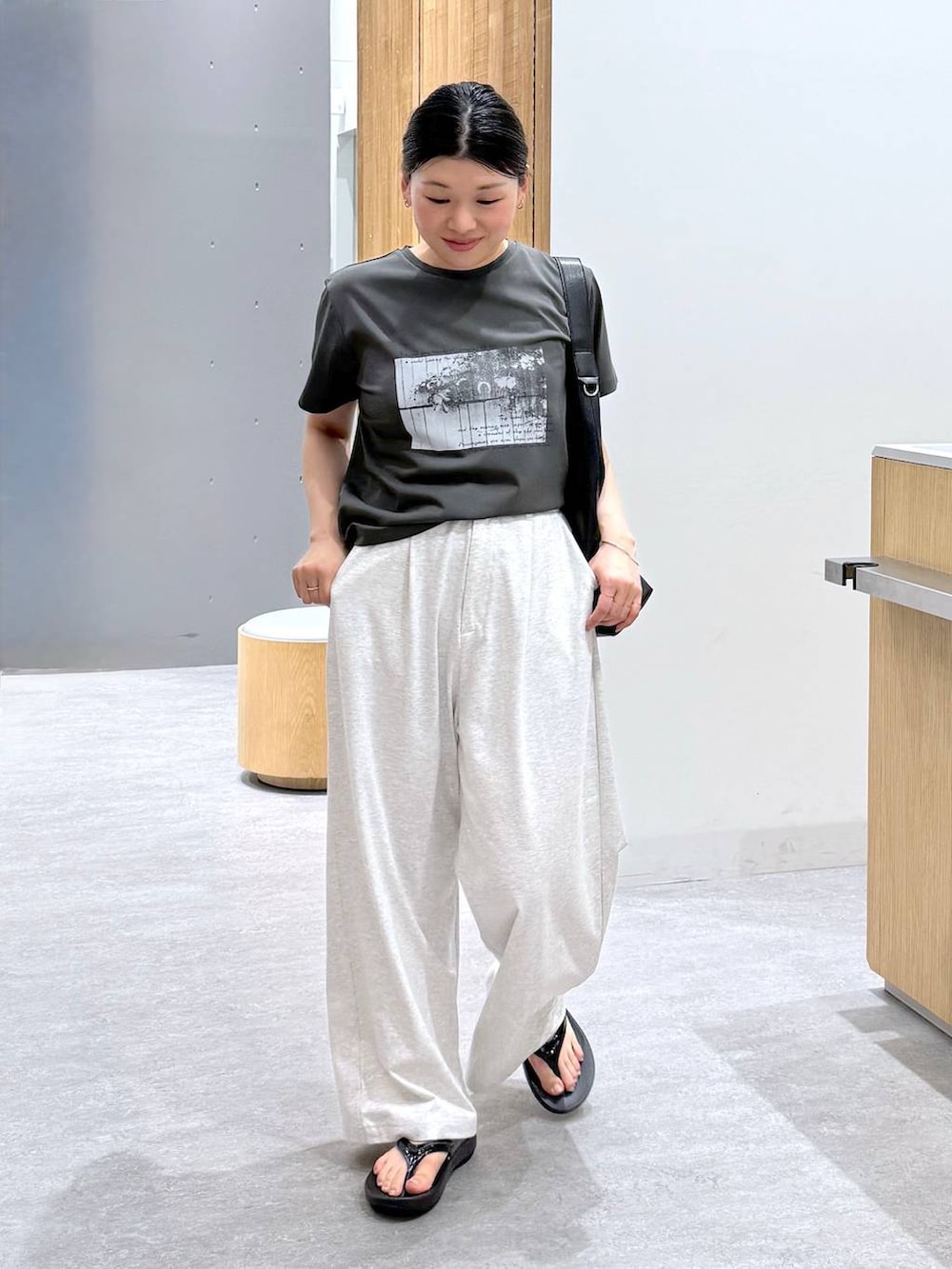 ブラック系のショルダーバッグ、グレー系のTシャツ/カットソー、グレー系のその他パンツを着用したレディースの春コーディネートの2枚目の写真