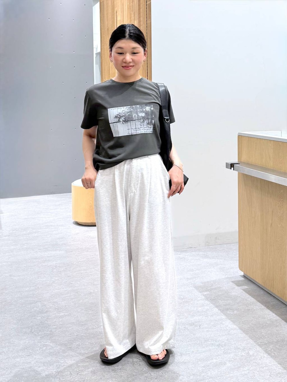 ブラック系のショルダーバッグ、グレー系のTシャツ/カットソー、グレー系のその他パンツを着用したレディースの春コーディネートの6枚目の写真