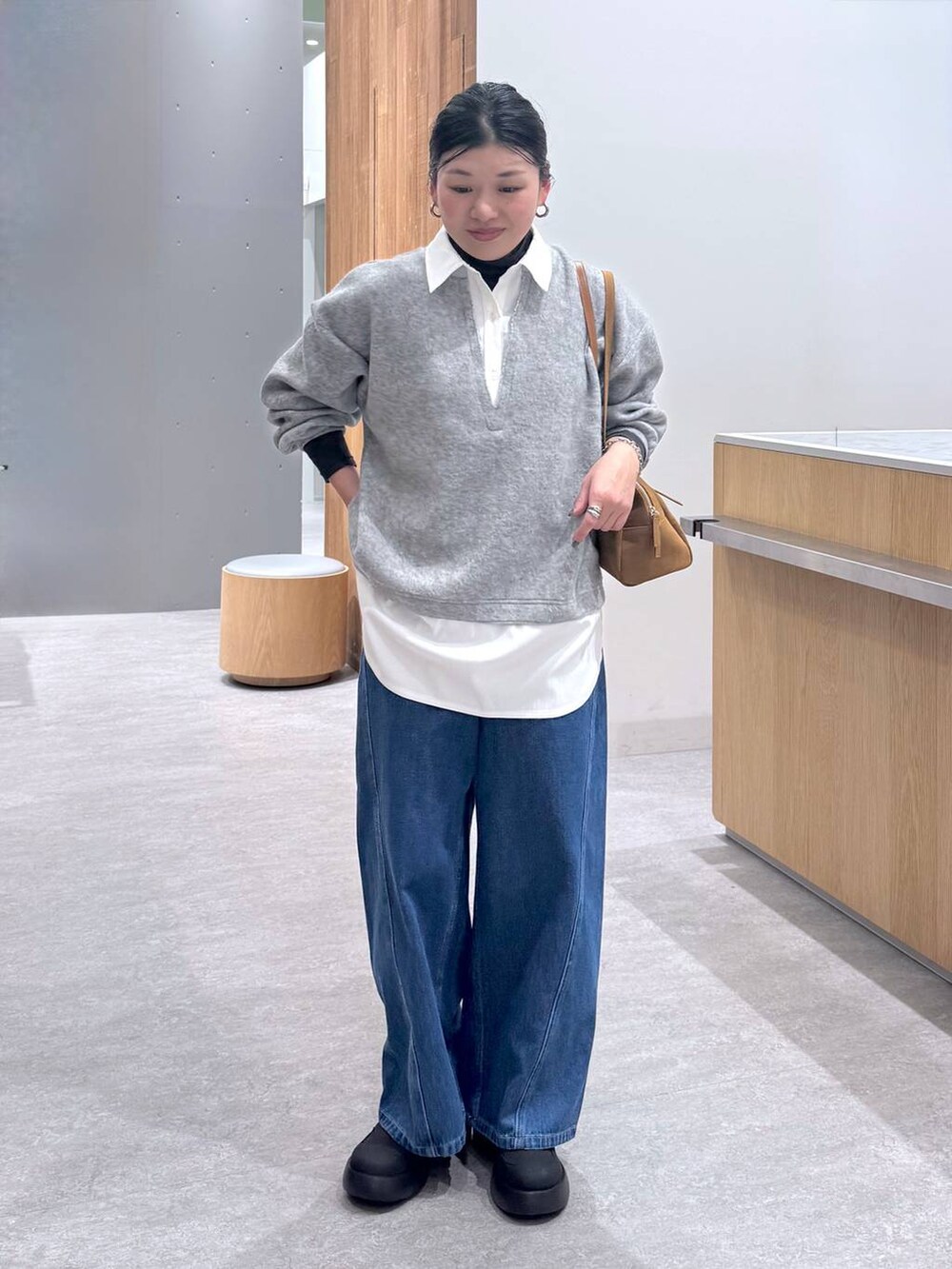 ブラック系のレインシューズ、イエロー系のボストンバッグ、グレー系のTシャツ/カットソーを着用したレディースの冬コーディネートの5枚目の写真