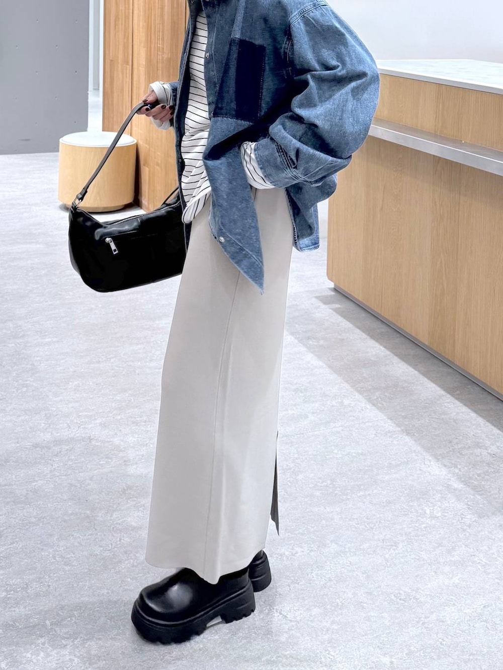 グレー系のスカート、ブルー系のシャツ/ブラウス、ブラック系のショルダーバッグを着用したレディースの冬コーディネートの3枚目の写真