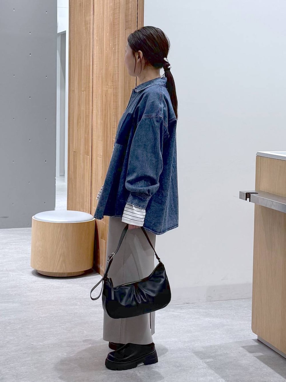 グレー系のスカート、ブルー系のシャツ/ブラウス、ブラック系のショルダーバッグを着用したレディースの冬コーディネートの5枚目の写真