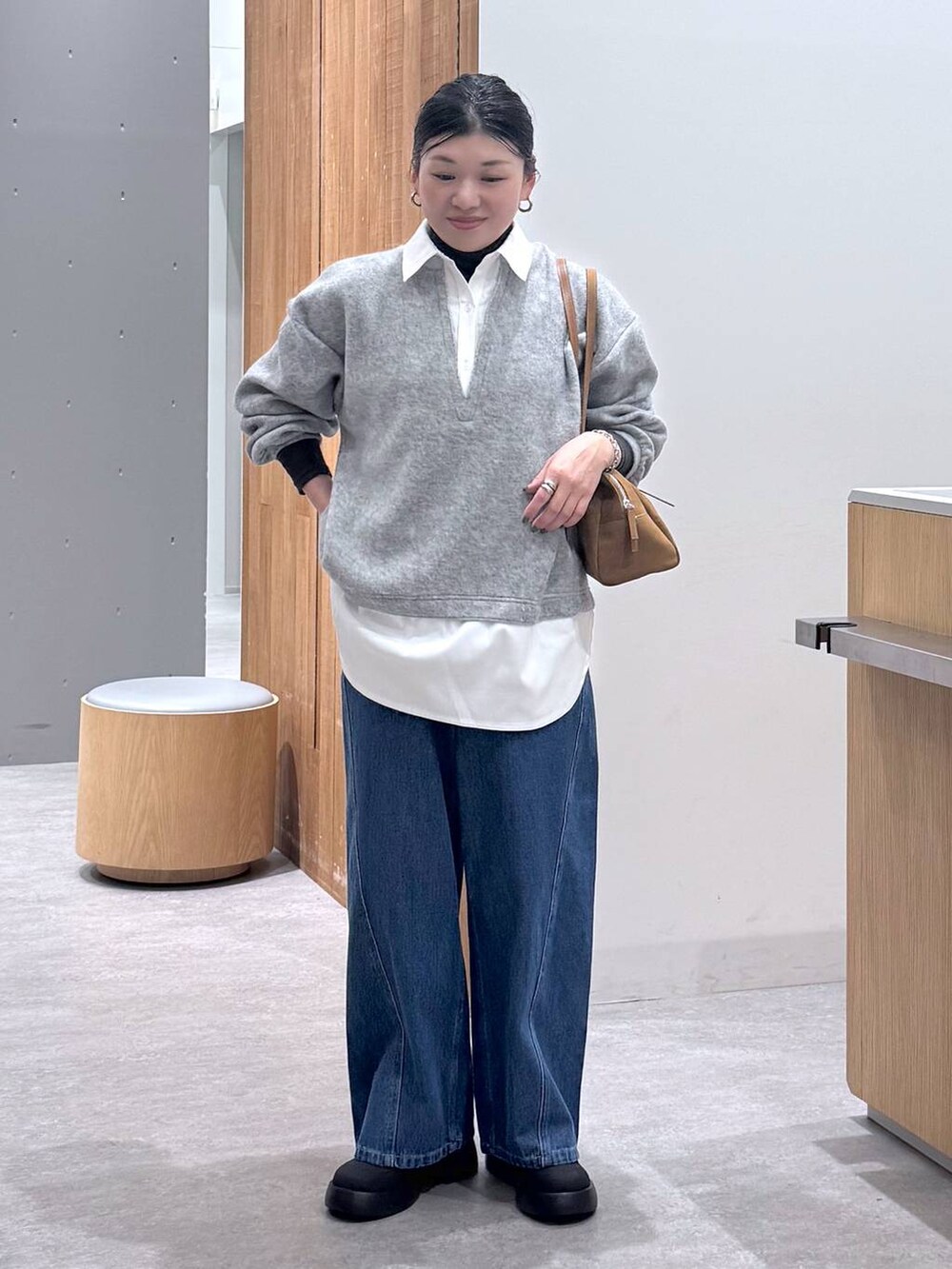 ブラック系のレインシューズ、イエロー系のボストンバッグ、グレー系のTシャツ/カットソーを着用したレディースの冬コーディネートの7枚目の写真