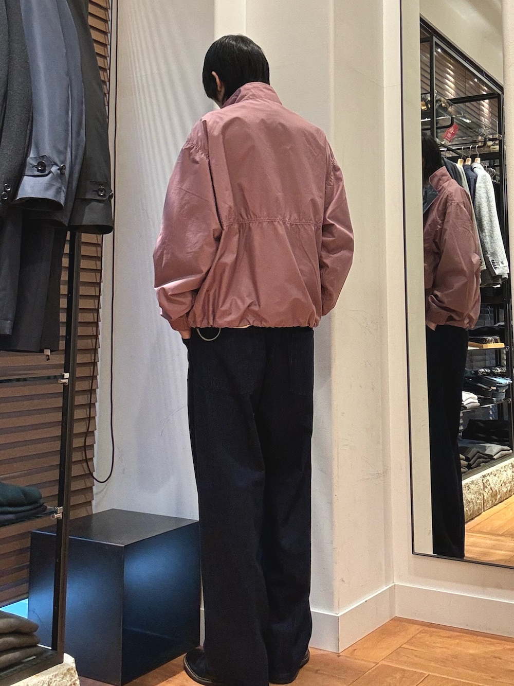 ピンク系のテーラードジャケット、ホワイト系のニット/セーター、ブルー系のデニムパンツを着用したメンズの冬コーディネートの2枚目の写真