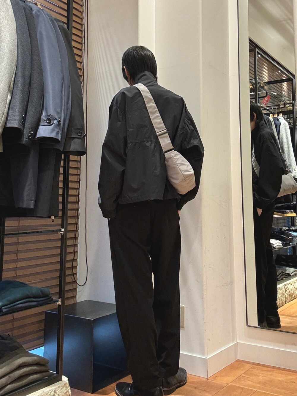 グレー系のテーラードジャケット、ブラック系のその他パンツ、グレー系のショルダーバッグを着用したメンズの冬コーディネートの2枚目の写真