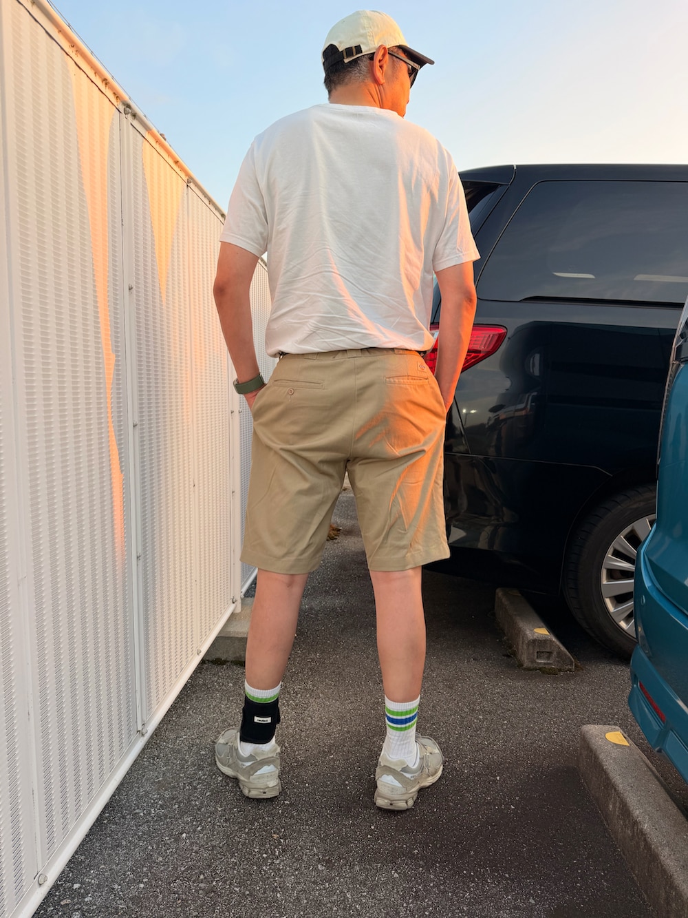 ホワイト系のTシャツ/カットソー、ベージュ系のその他パンツ、グレー系のスニーカーを着用したメンズの夏コーディネートの2枚目の写真