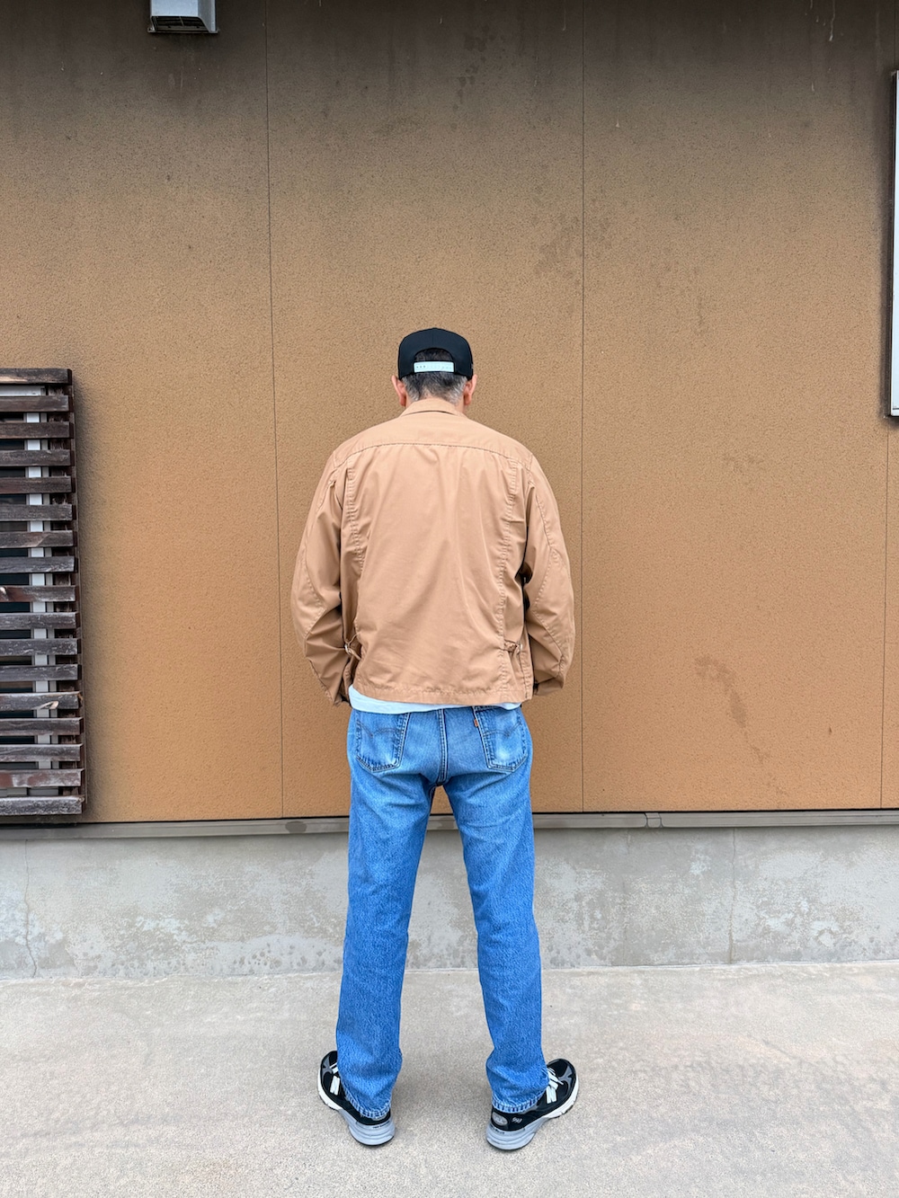ブラック系のスニーカー、ブラック系のポロシャツ、ホワイト系のTシャツ/カットソーを着用したメンズの秋コーディネートの2枚目の写真