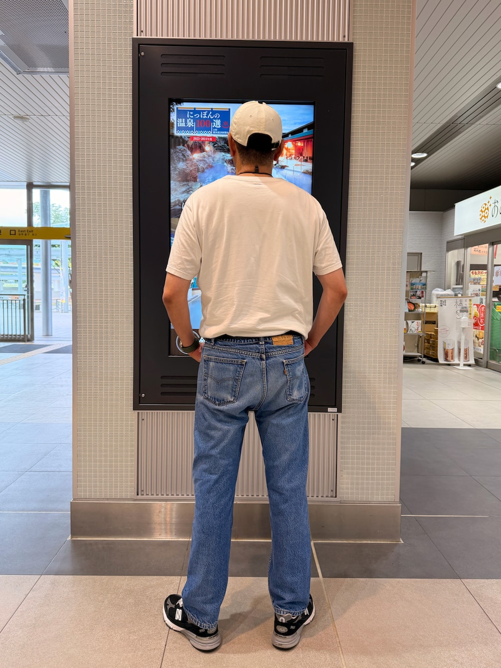 ホワイト系のTシャツ/カットソー、ブルー系のデニムパンツ、ブラック系のスニーカーを着用したメンズの夏コーディネートの2枚目の写真