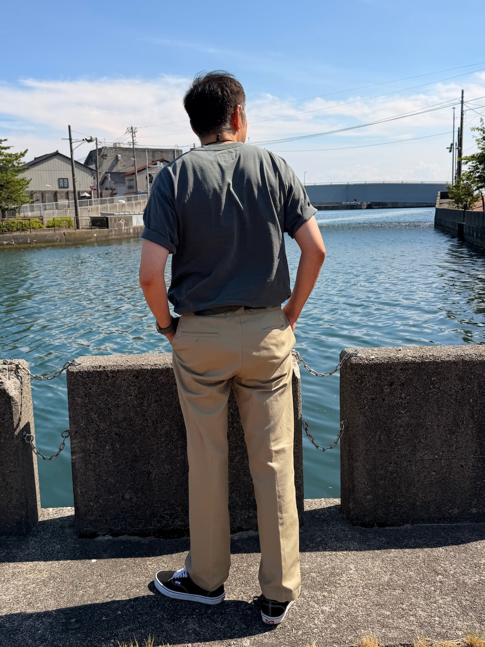 グレー系のTシャツ/カットソー、ベージュ系のチノパンツ、ブラック系のスニーカーを着用したメンズの夏コーディネートの2枚目の写真