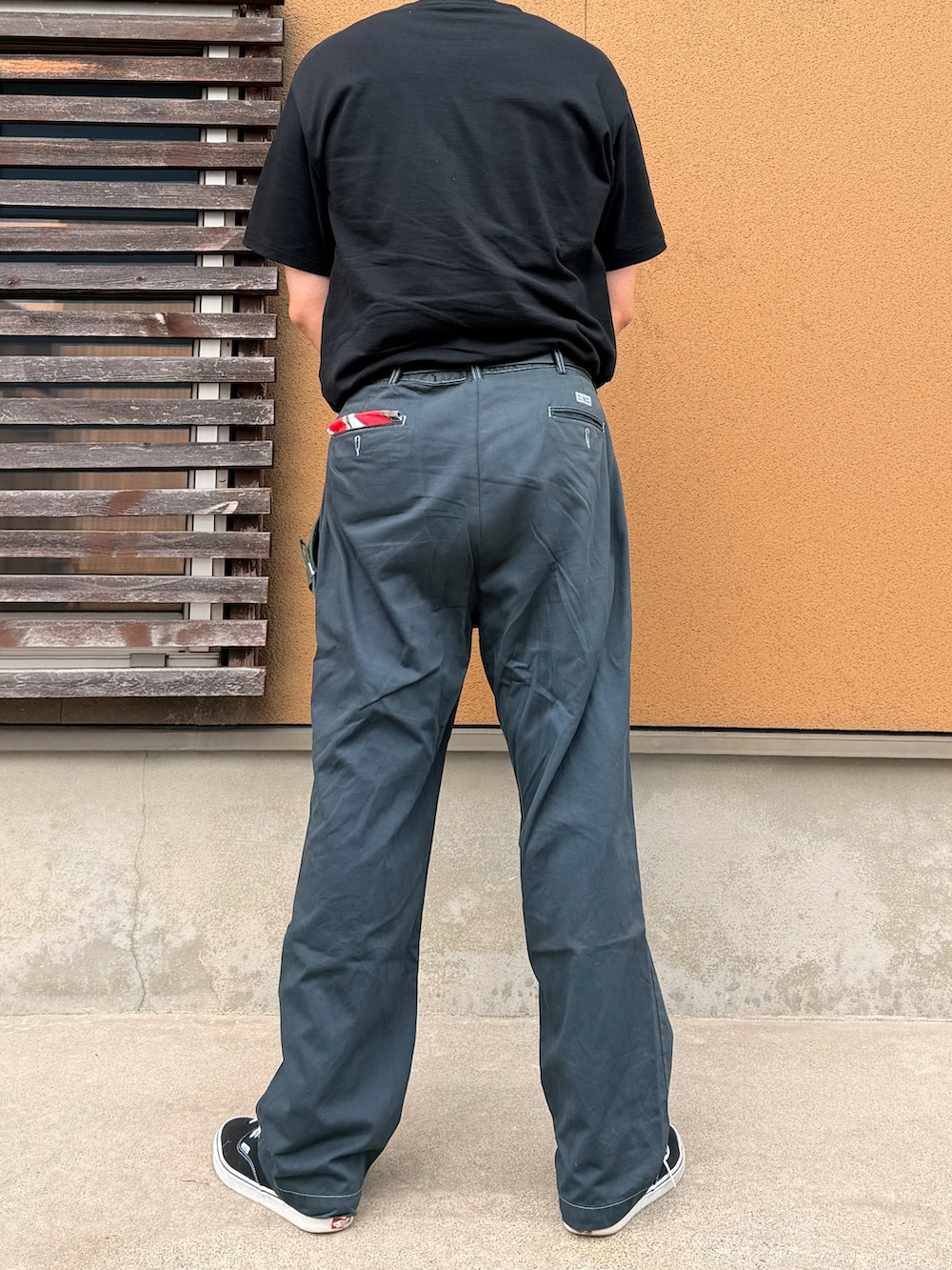 ブラック系のTシャツ/カットソー、ブラック系のチノパンツ、ブラック系のスニーカーを着用したメンズの夏コーディネートの2枚目の写真