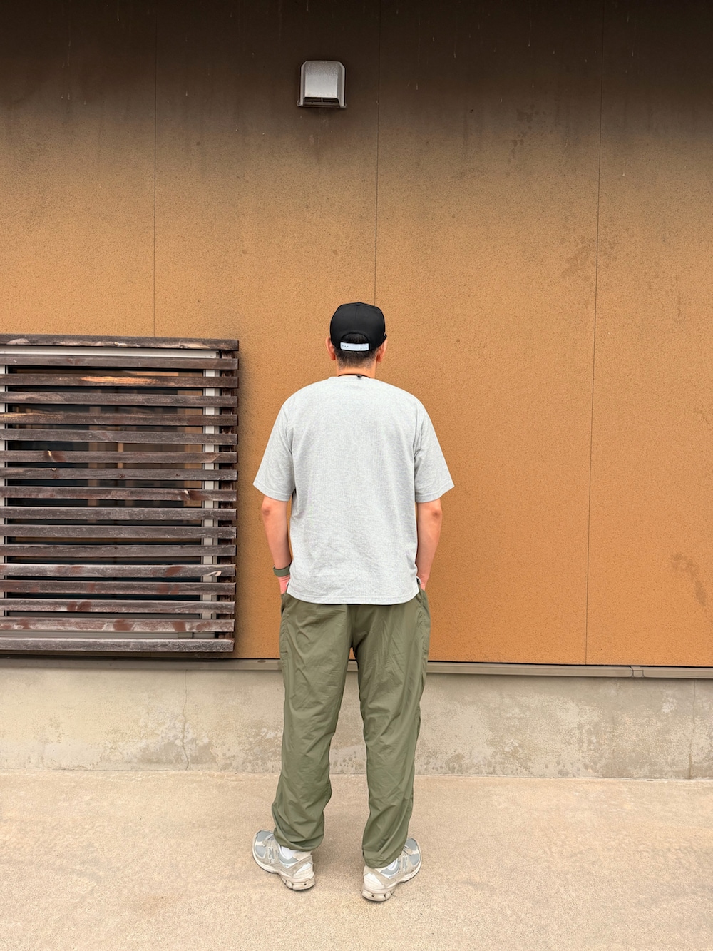 グレー系のTシャツ/カットソー、グリーン系のカーゴパンツ、グレー系のスニーカーを着用したメンズの夏コーディネートの2枚目の写真