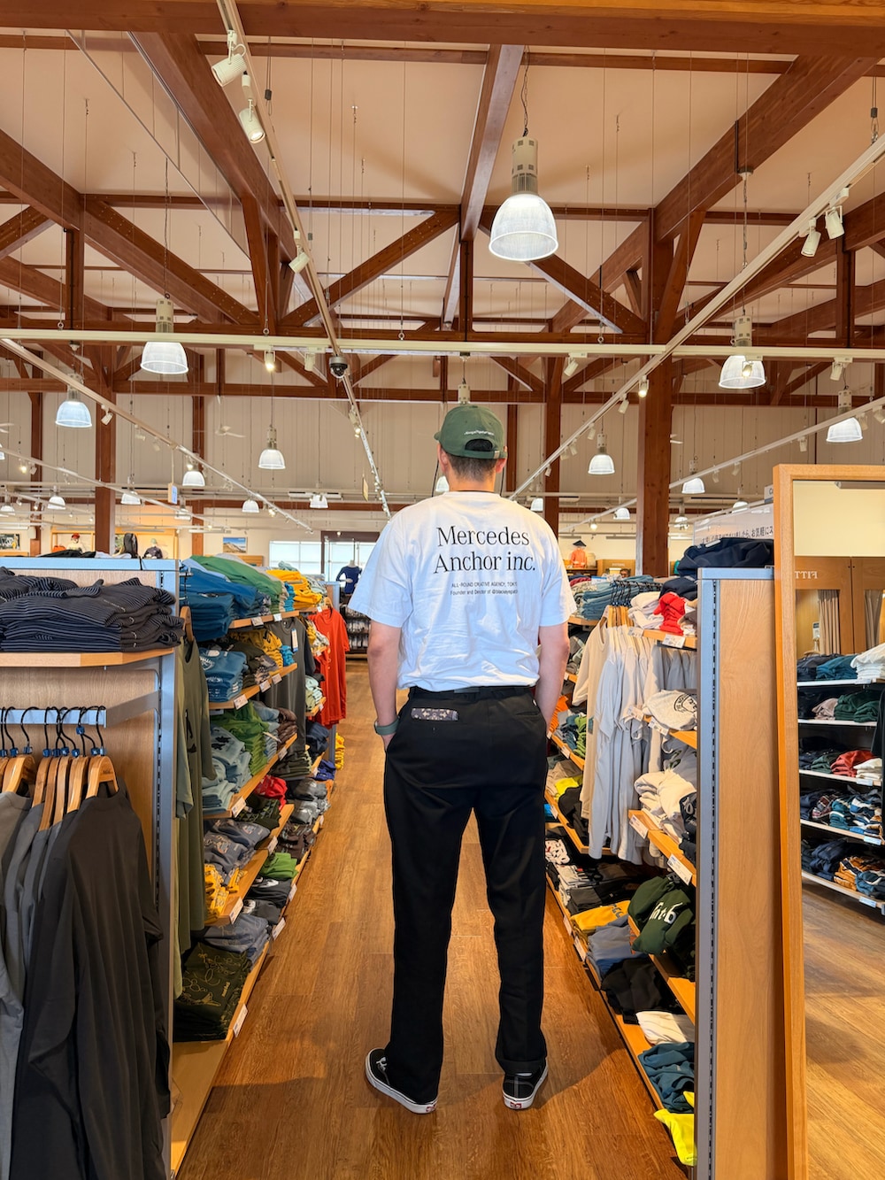 ホワイト系のTシャツ/カットソー、ブラック系のチノパンツ、ブラック系のスニーカーを着用したメンズの夏コーディネートの2枚目の写真