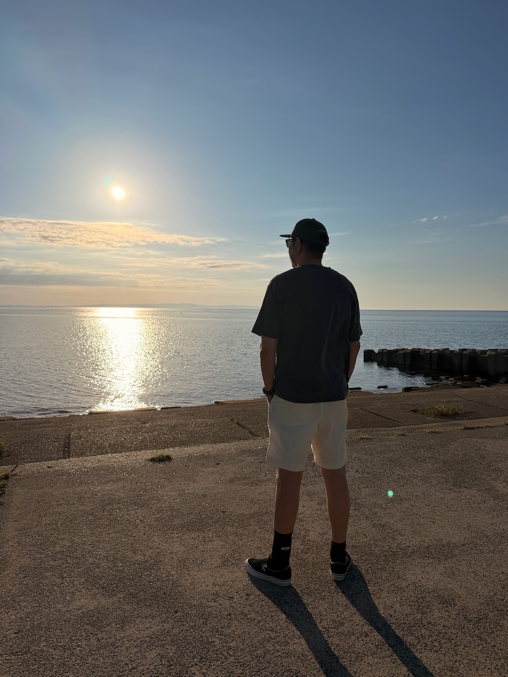 グレー系のTシャツ/カットソー、ホワイト系のその他パンツ、ブラック系のスリッポンを着用したメンズの夏コーディネートの2枚目の写真