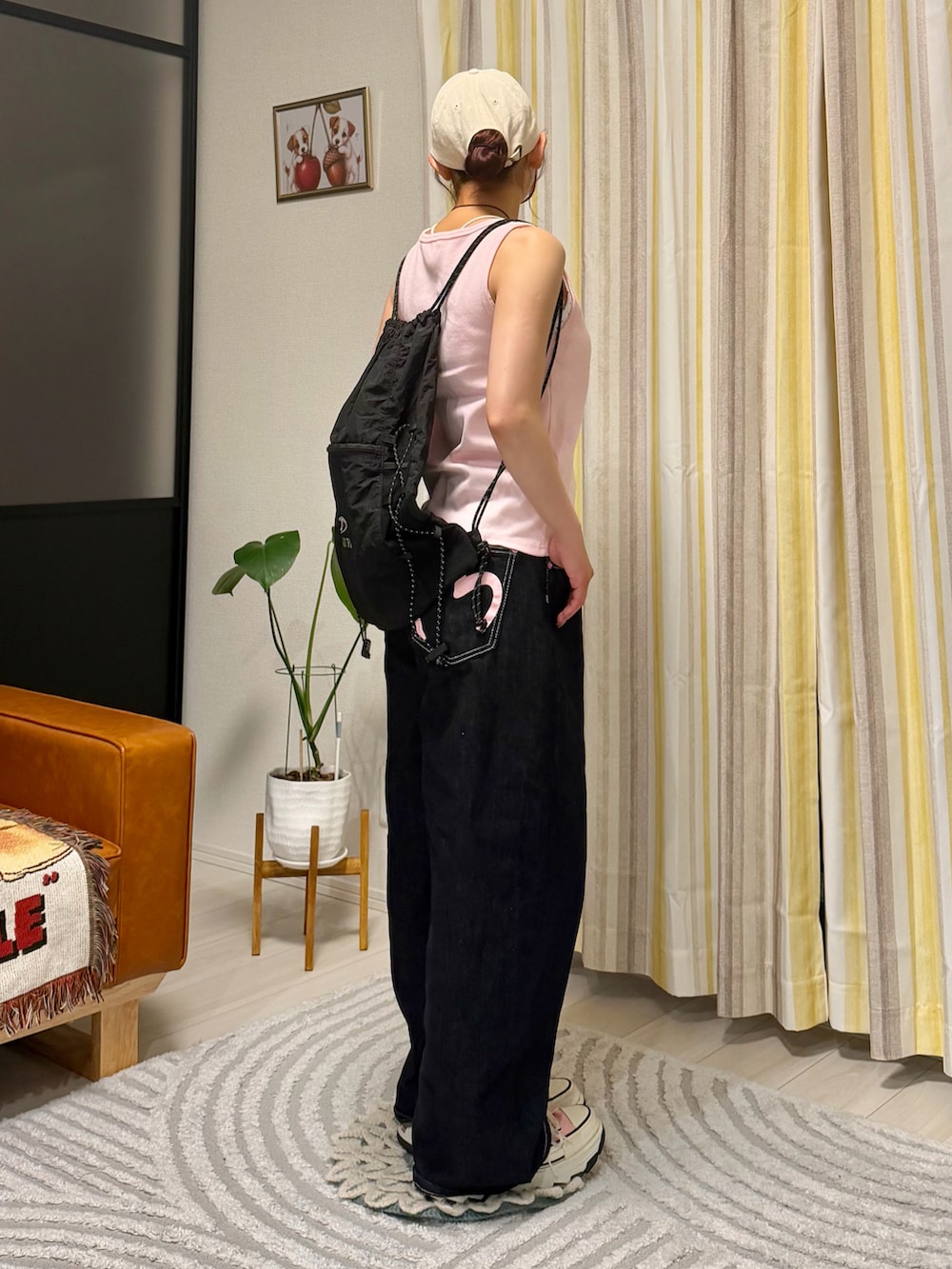 ピンク系のタンクトップ、ブラック系のデニムパンツ、ピンク系のスニーカーを着用したレディースの春コーディネートの2枚目の写真