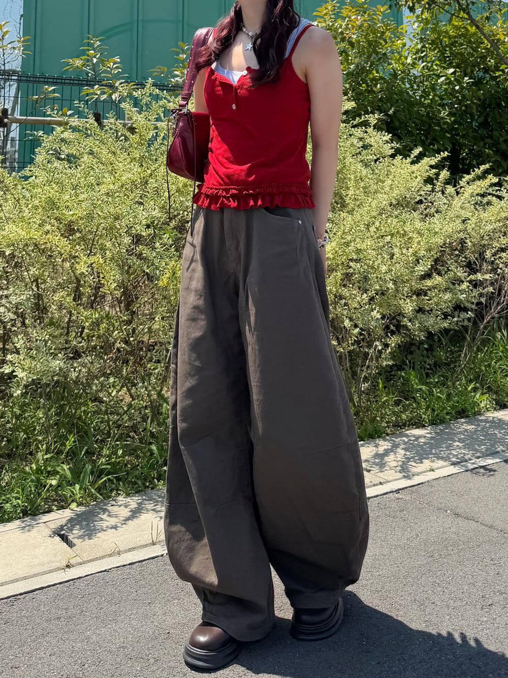 グレー系のタンクトップ、レッド系のキャミソール、レッド系のショルダーバッグを着用したレディースの夏コーディネートの2枚目の写真