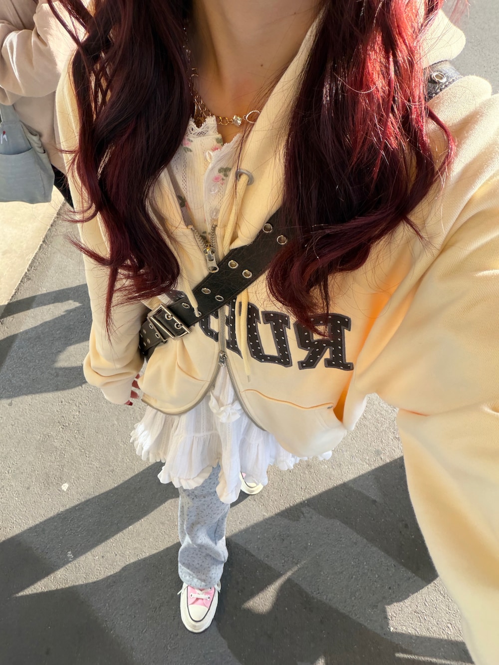 ホワイト系のTシャツ/カットソー、イエロー系のパーカー、グレー系のスウェットパンツを着用したレディースの秋コーディネートの2枚目の写真