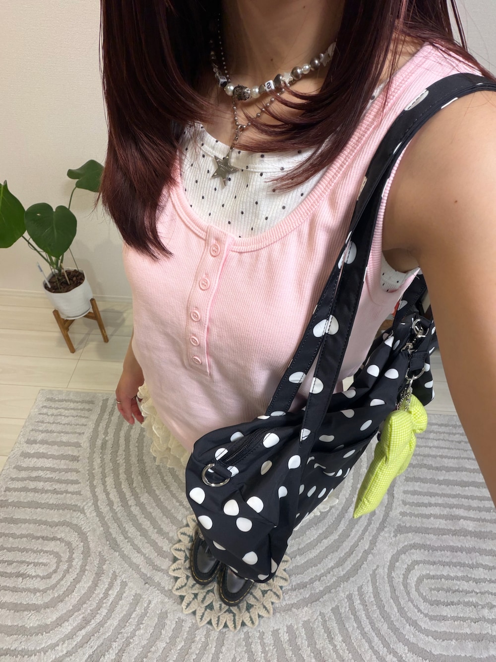 ピンク系のタンクトップ、ブラック系のローファー、ホワイト系のパンツを着用したレディースの春コーディネートの2枚目の写真