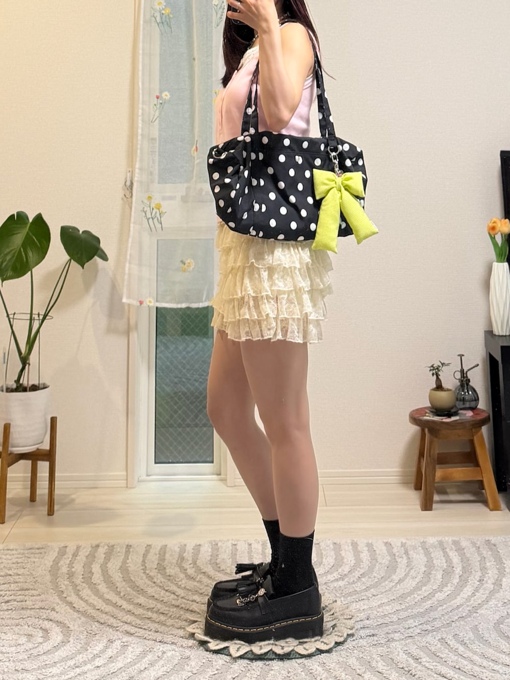 ピンク系のタンクトップ、ブラック系のローファー、ホワイト系のパンツを着用したレディースの春コーディネートの3枚目の写真