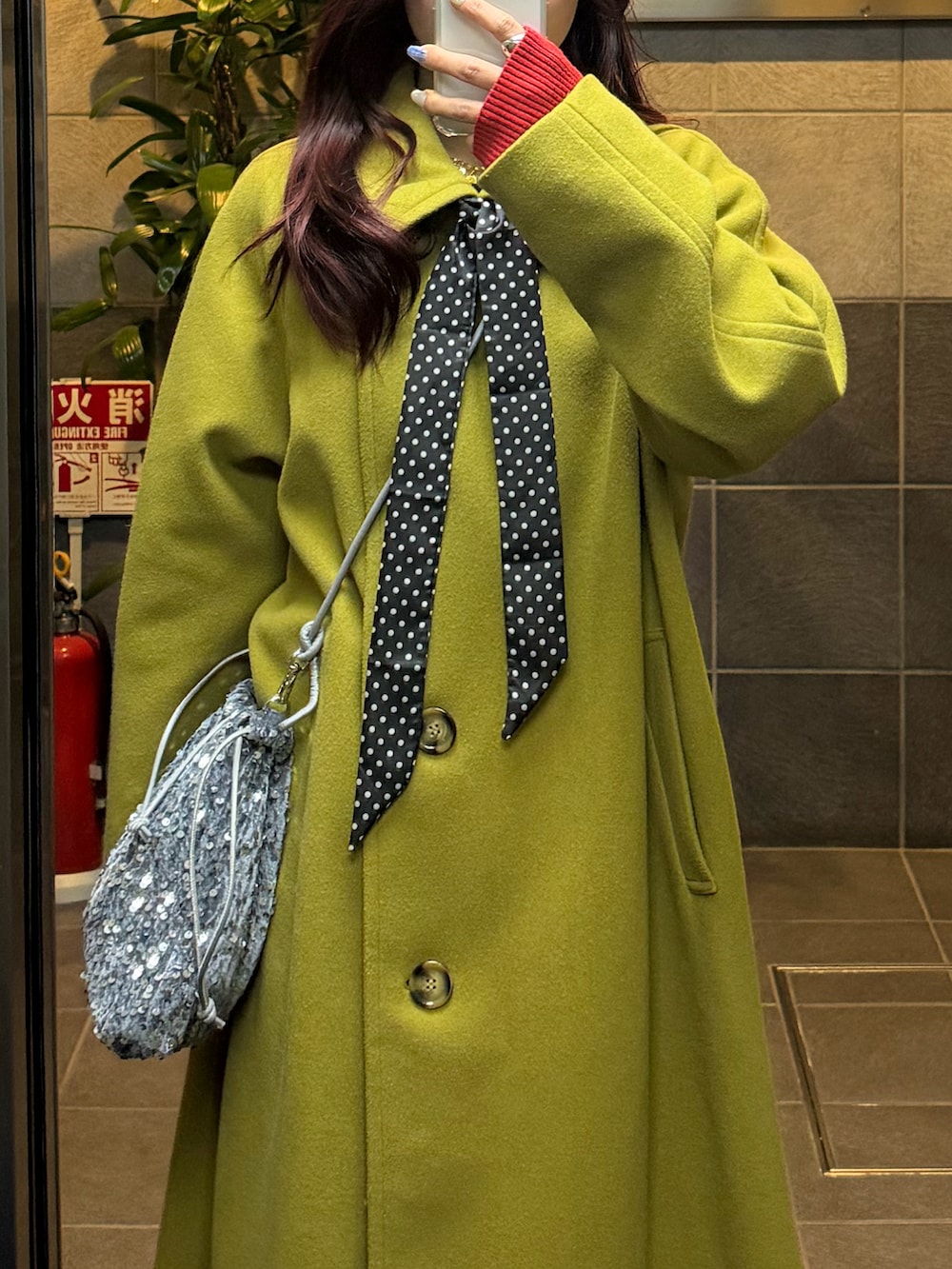 イエロー系のダウンジャケット/コート、レッド系のニット/セーター、ブラック系のフォーマルスーツ/小物を着用したレディースの冬コーディネートの3枚目の写真