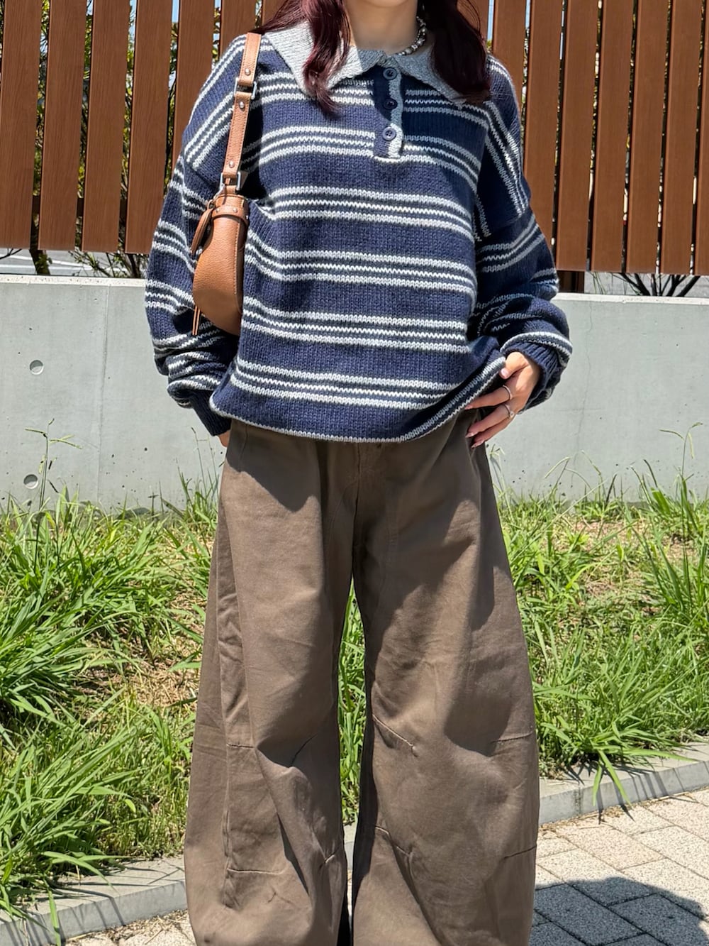 ブラウン系のデニムパンツ、ブラック系のシューズ、ブラウン系のショルダーバッグを着用したレディースの秋コーディネートの2枚目の写真