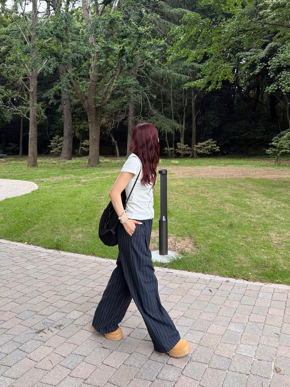 ブラック系のバックパック/リュック、ホワイト系のTシャツ/カットソー、ブルー系のパンツを着用したレディースの夏コーディネートの2枚目の写真