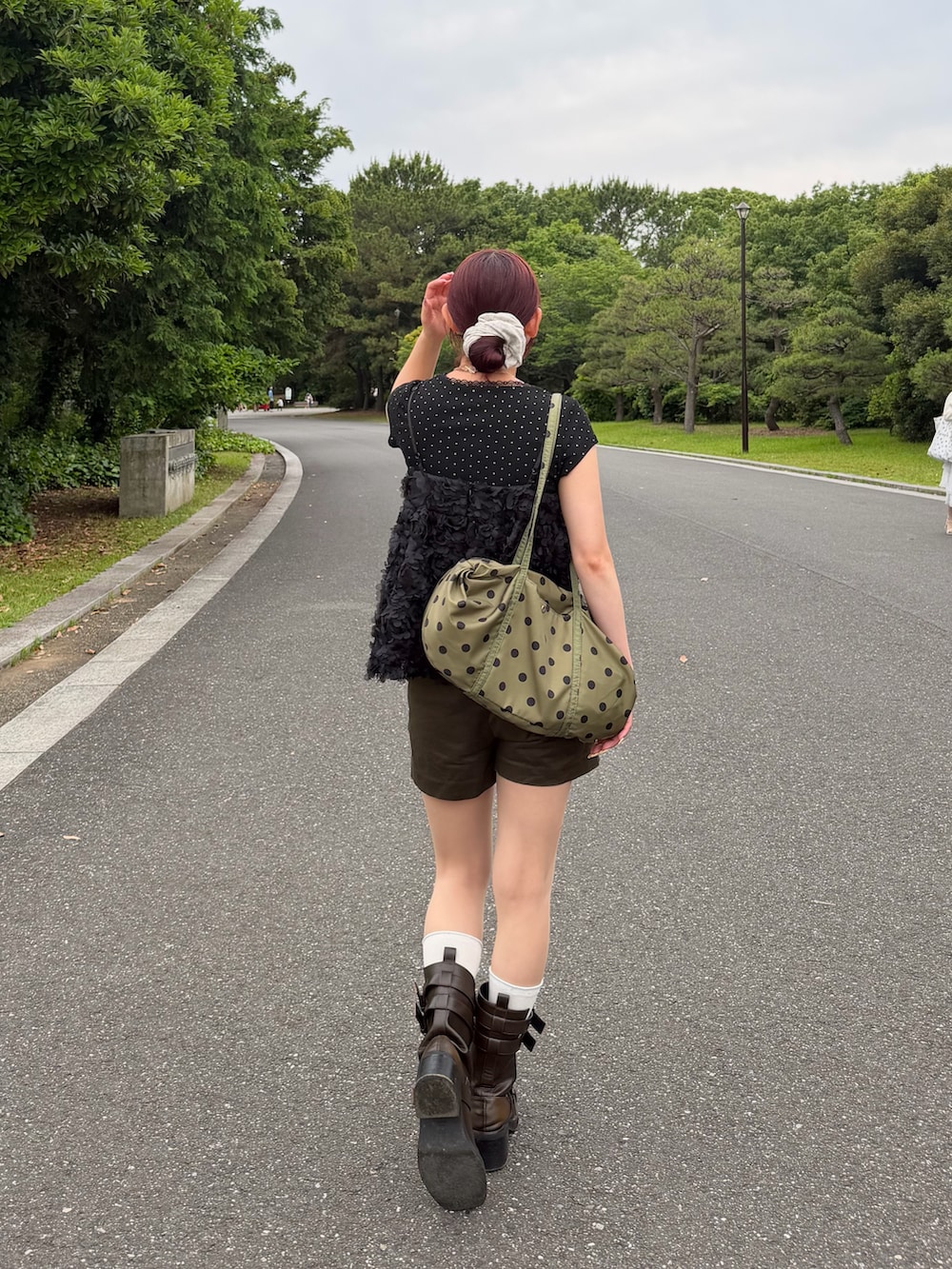 ブラック系のトップス、グリーン系のバッグ、グリーン系のその他パンツを着用したレディースの夏コーディネートの2枚目の写真