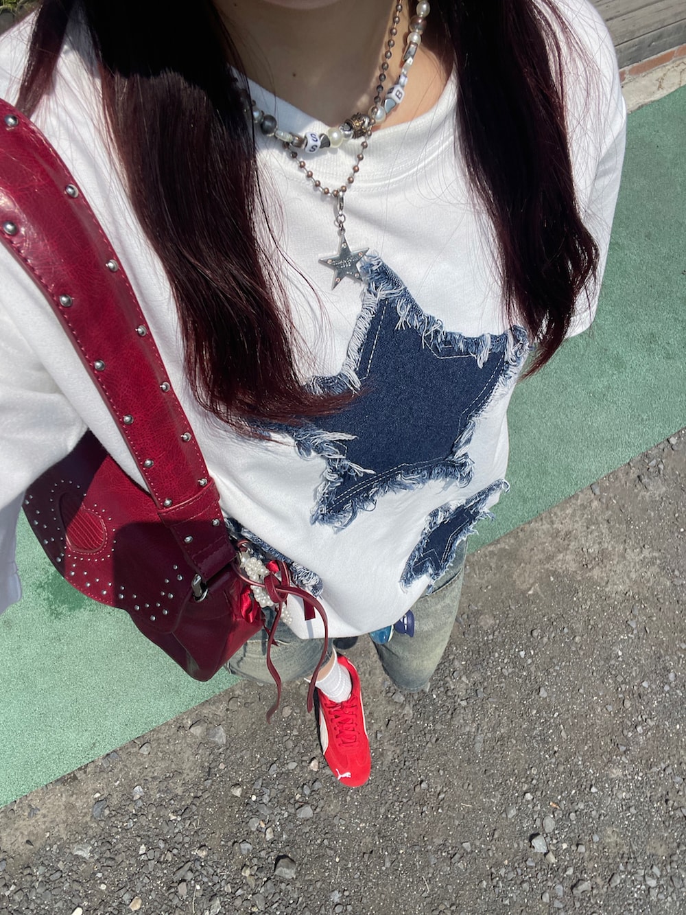 レッド系のショルダーバッグ、レッド系のスニーカー、ホワイト系のTシャツ/カットソーを着用したレディースの春コーディネートの2枚目の写真
